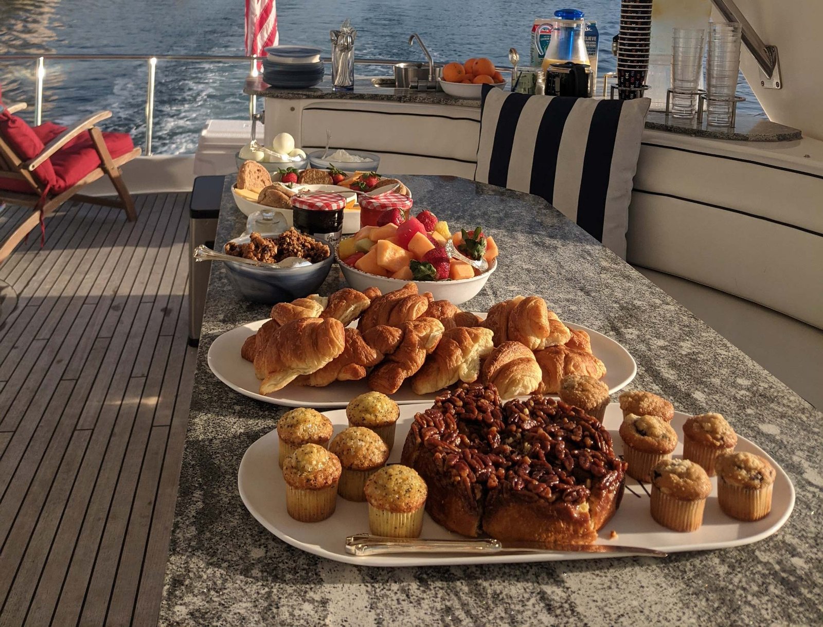 Photo of a spread of pastries and fruit on a table on a yacht.